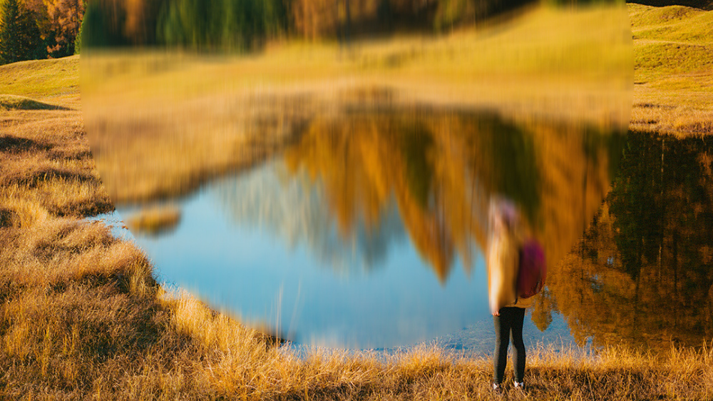 Landschaftsbild mit See und Wald, in der Mitte unscharf