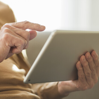 Nahaufnahme von Händen, die ein Tablet halten