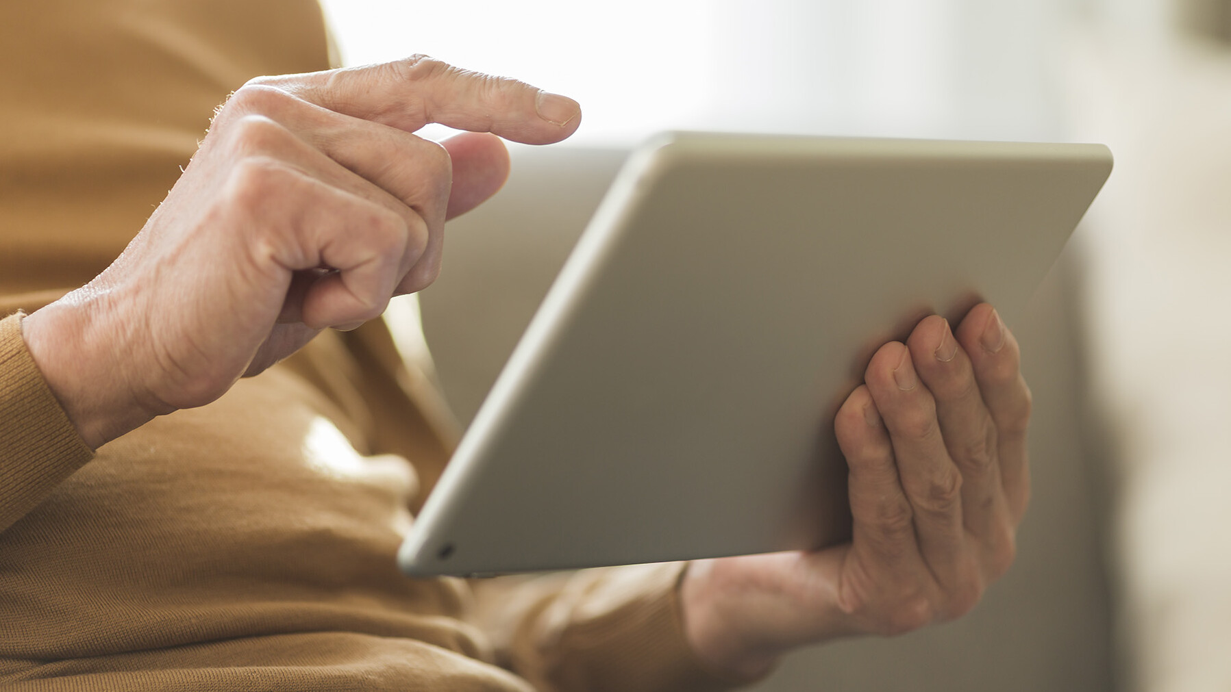 Nahaufnahme von Händen, die ein Tablet halten