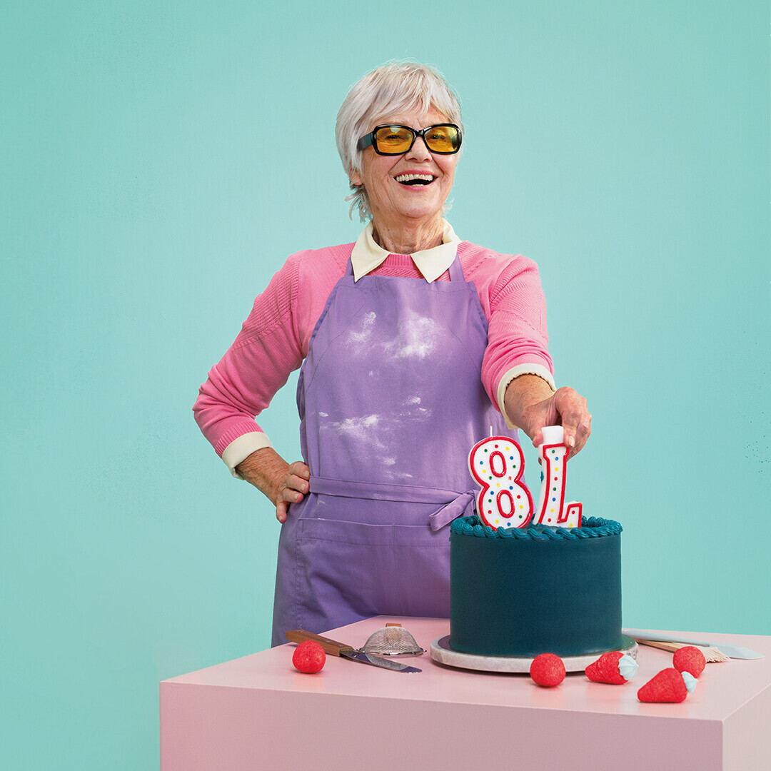 Eine ältere Dame hat einen Kuchen gebacken. Die Zahlen, die auf der Torte sind, sind falsch herum