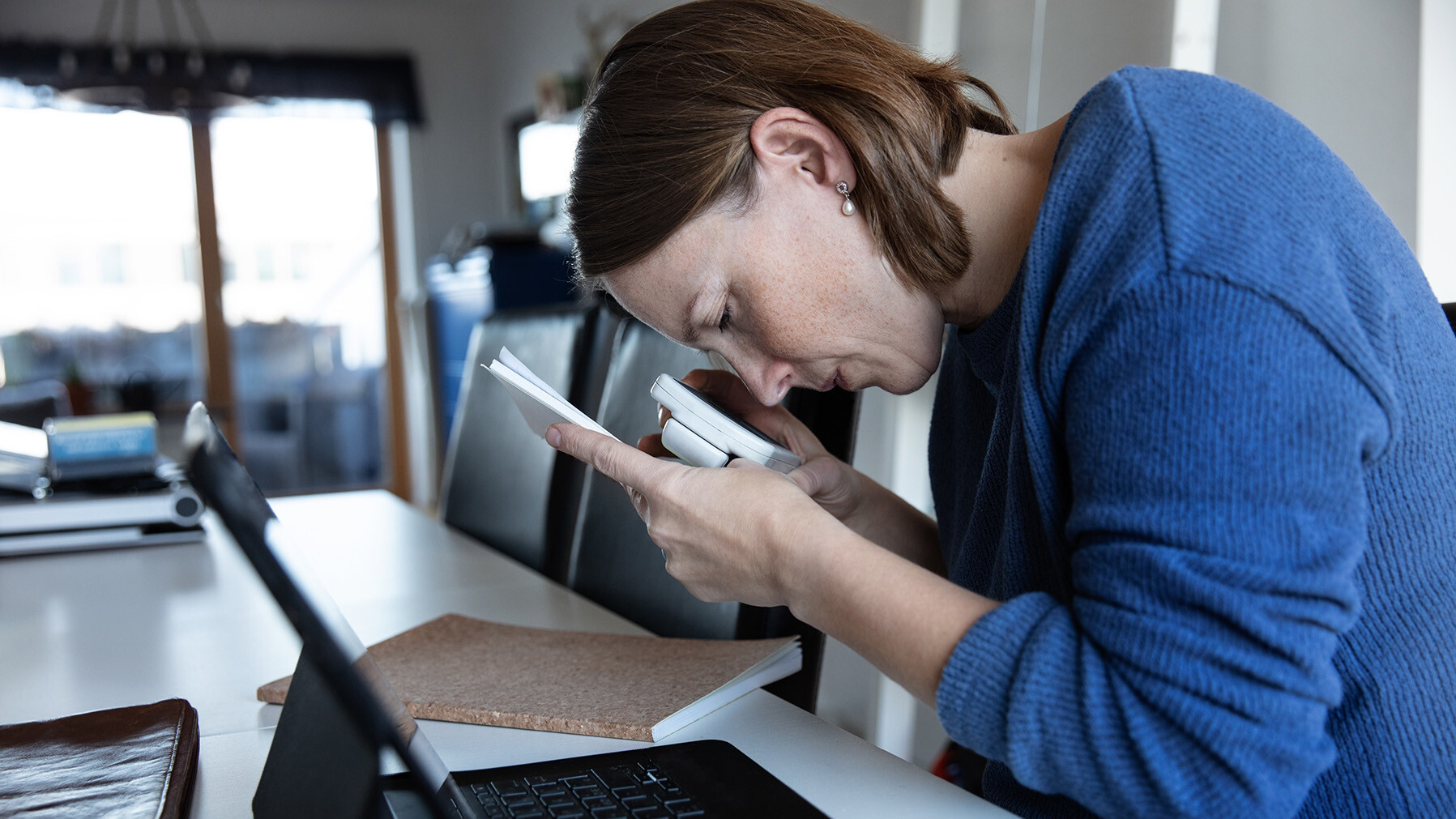 Frau liest mithilfe einer elektronischen Lupe ein Dokument