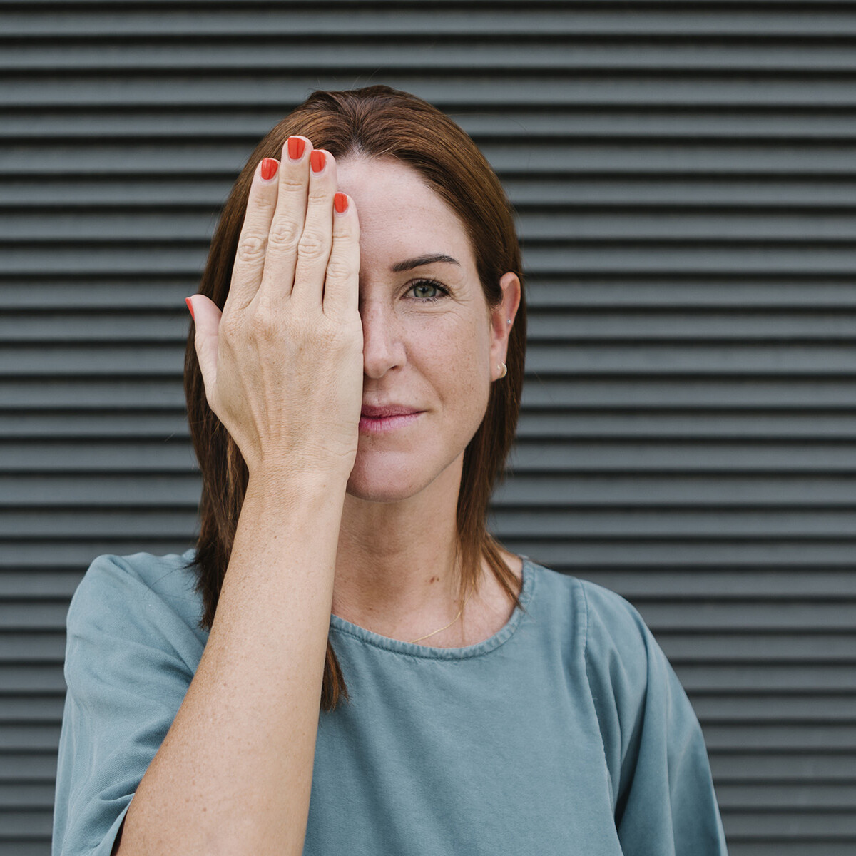 Frau hält rechtes Auge zu