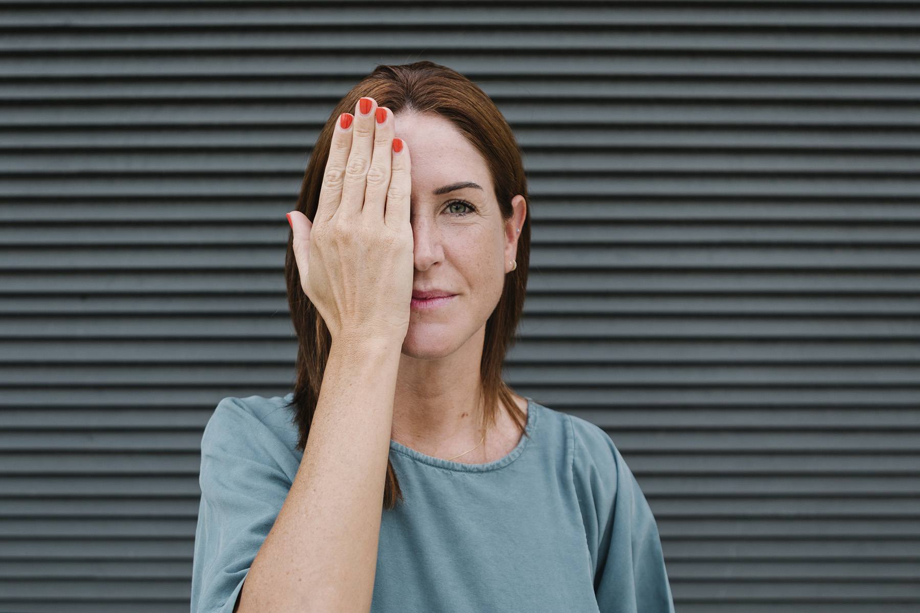 Frau hält rechtes Auge zu